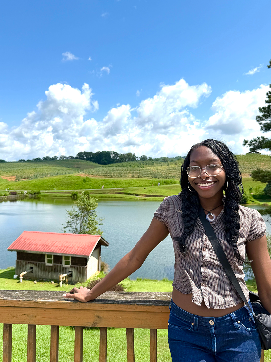 Sidney smiling on a deck overlooking a lake